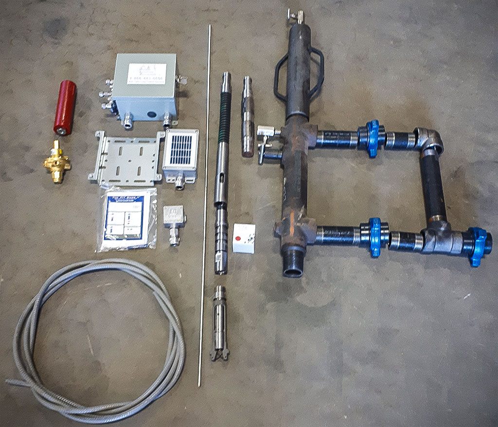 Plunger lift equipment laid out before shipping: lubricator, controller, plungers and springs